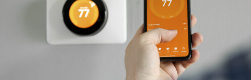Man uses a mobile phone with smart home app in modern living room
